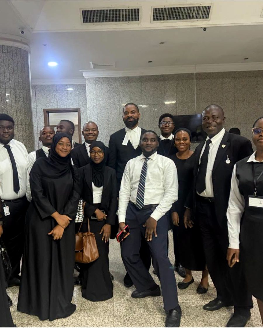 Deji Adeyanju in wig and gown with students at court