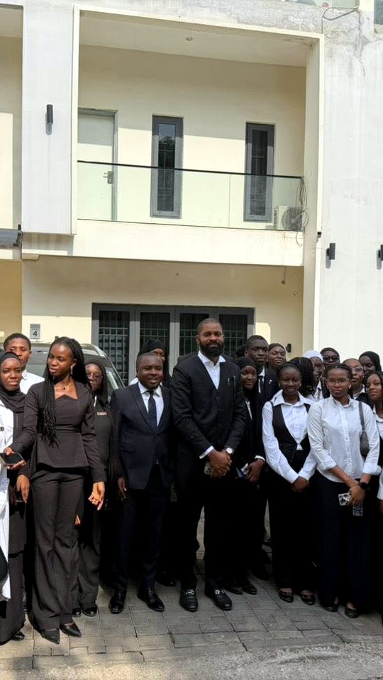 Deji Adeyanju with students outside a building in Abuja